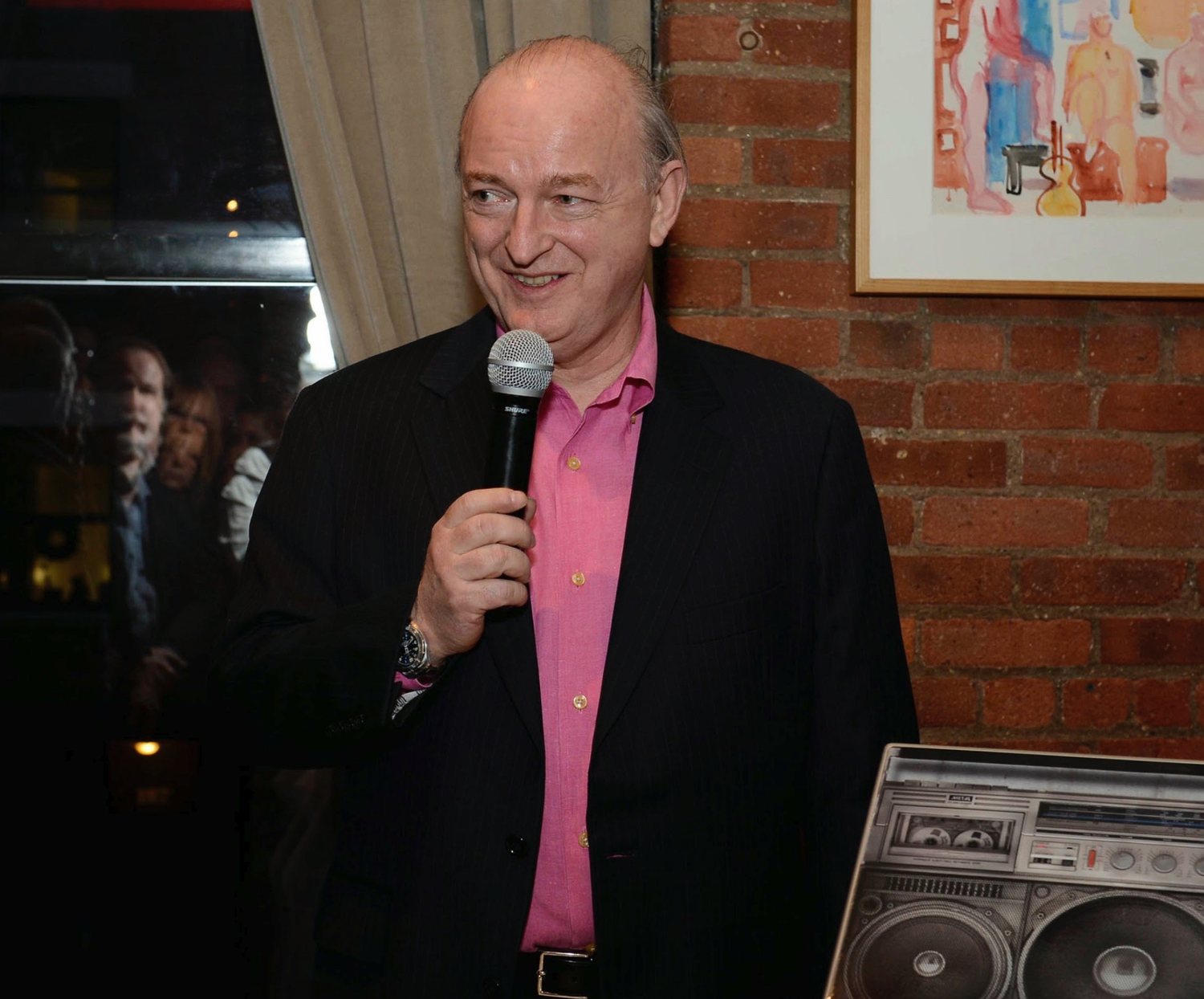 Dave Marsh smiling, holding a microphone, at a Kristen Ann Carr Fund benefit